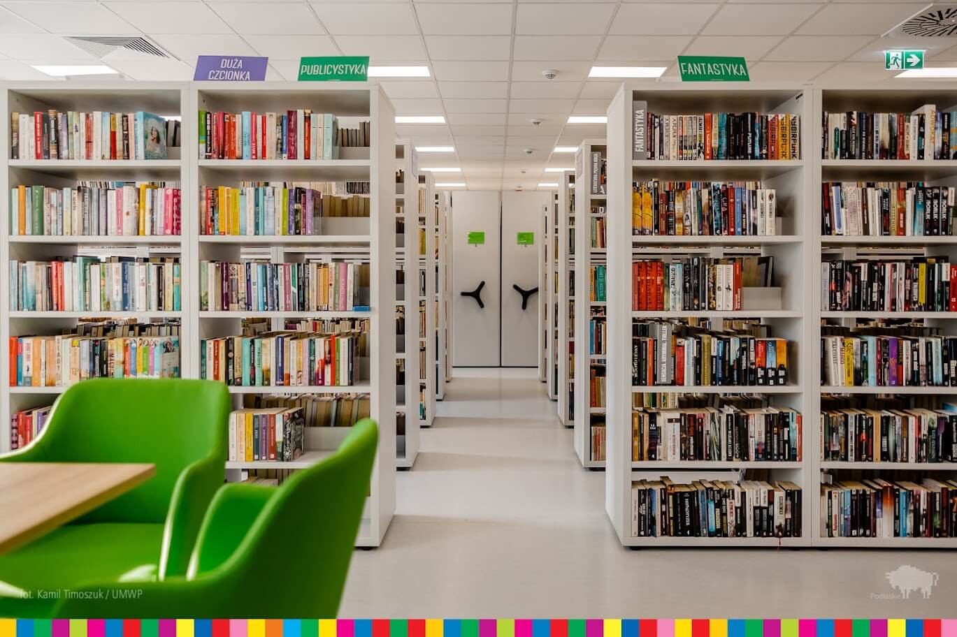 Sala biblioteczna z regałami pełnymi książek.