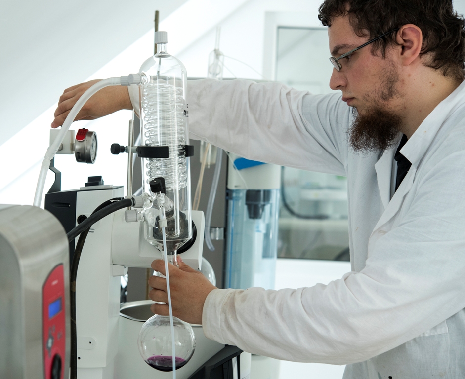   A laboratory employee is working on laboratory equipment