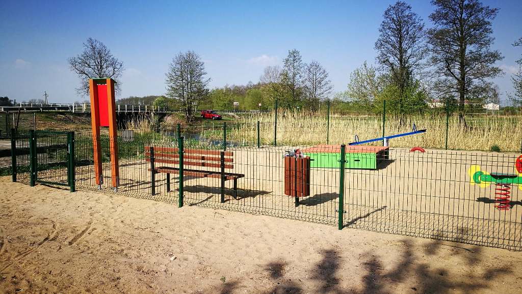 Ogrodzony plac zabaw z nawierzchnią piaskową