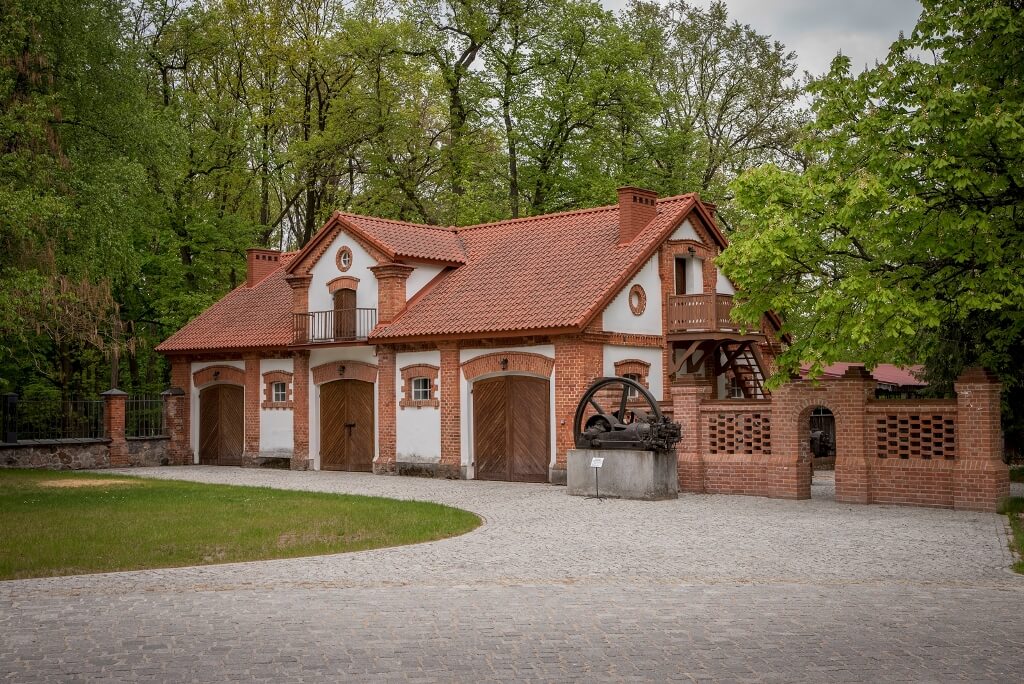 Fragment muru przy powozowni, w tle budynek