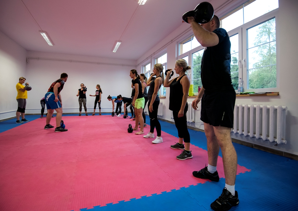 Uczestnicy zajęć fitness ćwiczą wewnatrz centrum