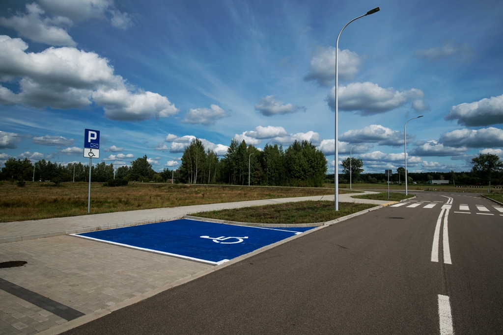 Ulica z miejscami parkingowymi, w tym jedno miejsce dla osób z niepełnosprawnością 